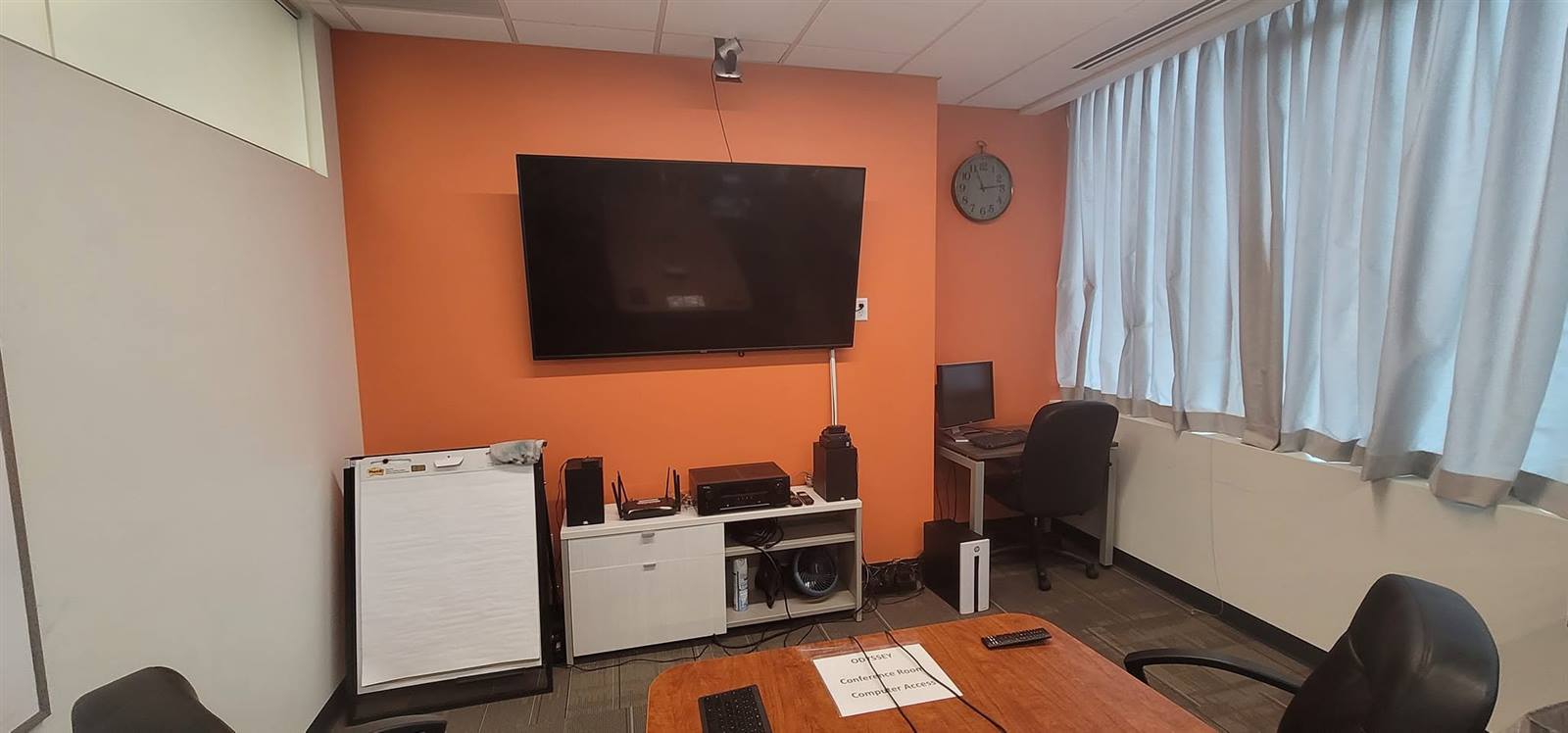Office interior with orange accent wall and TV mount